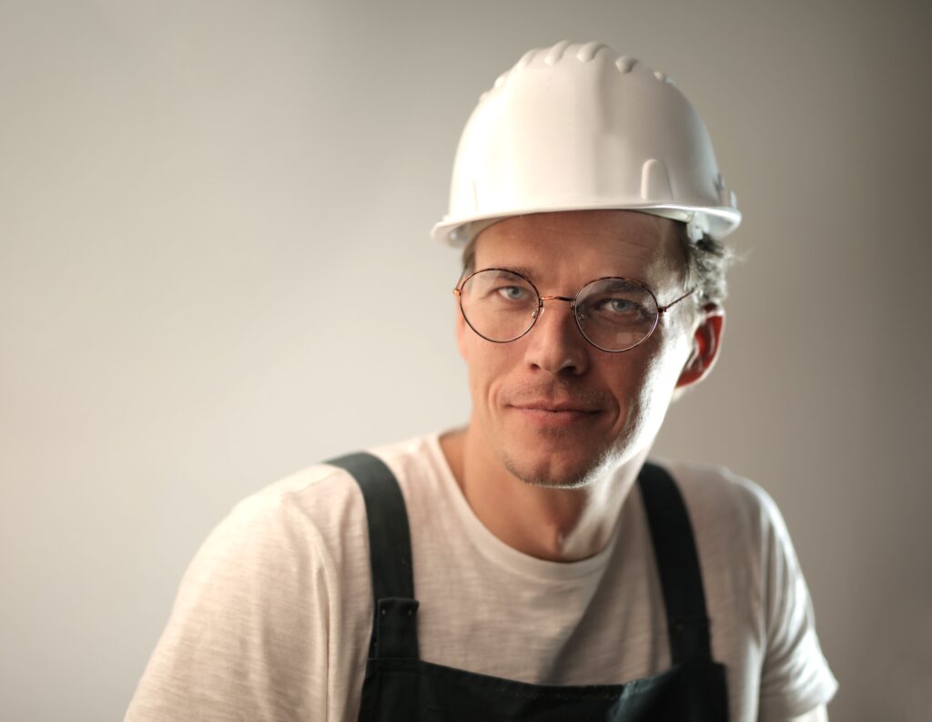 Portret van een ervaren vakman in werkkleding met bouwhelm