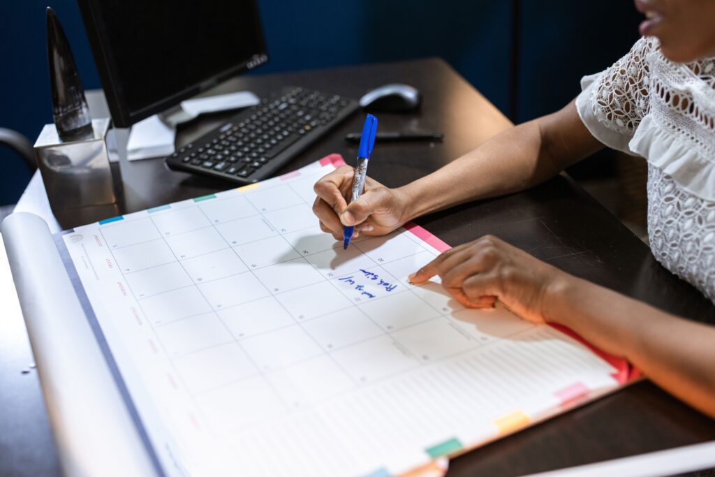 Persoon schrijft een afspraak in een kalender