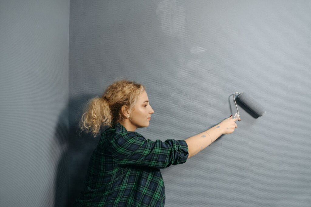 Vrouw schildert een muur met verfroller
